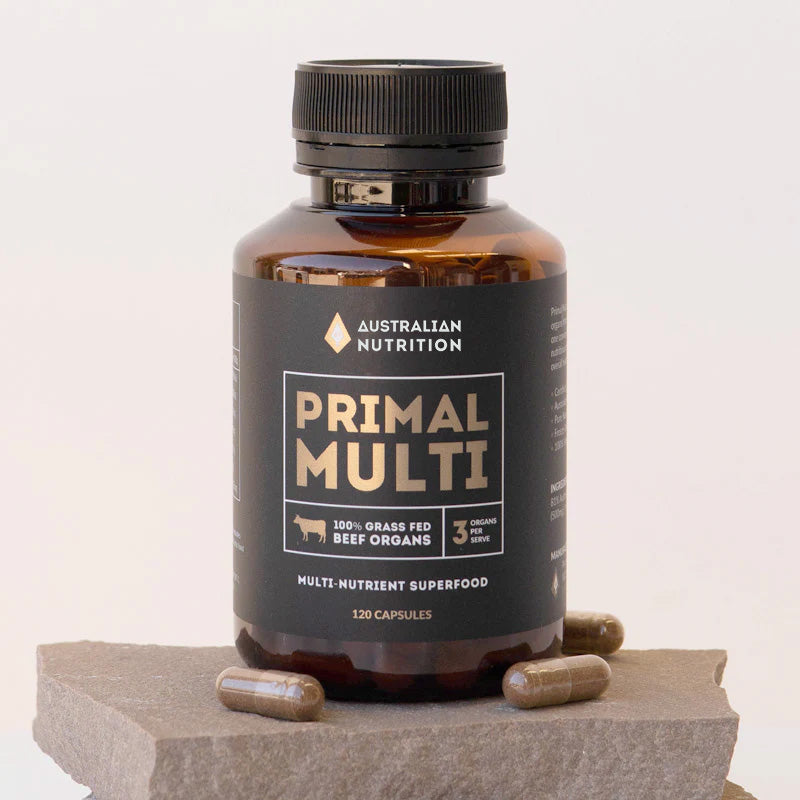 Bottle of Australian Nutrition Primal Multi beef organ supplement on a stone surface with a white background